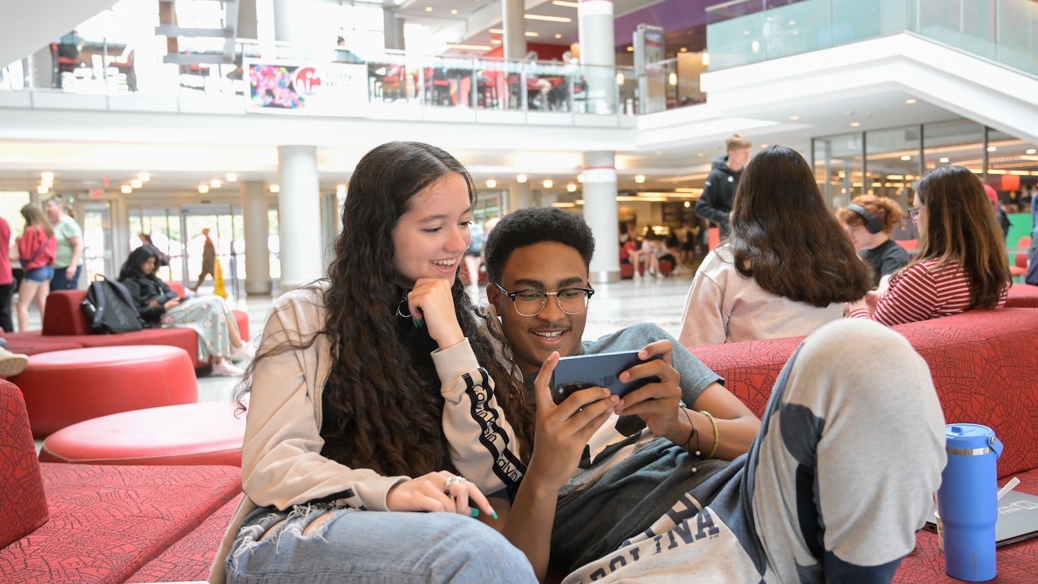 Students are sitting together and watching a funny video between classes in the Talley Student Union.