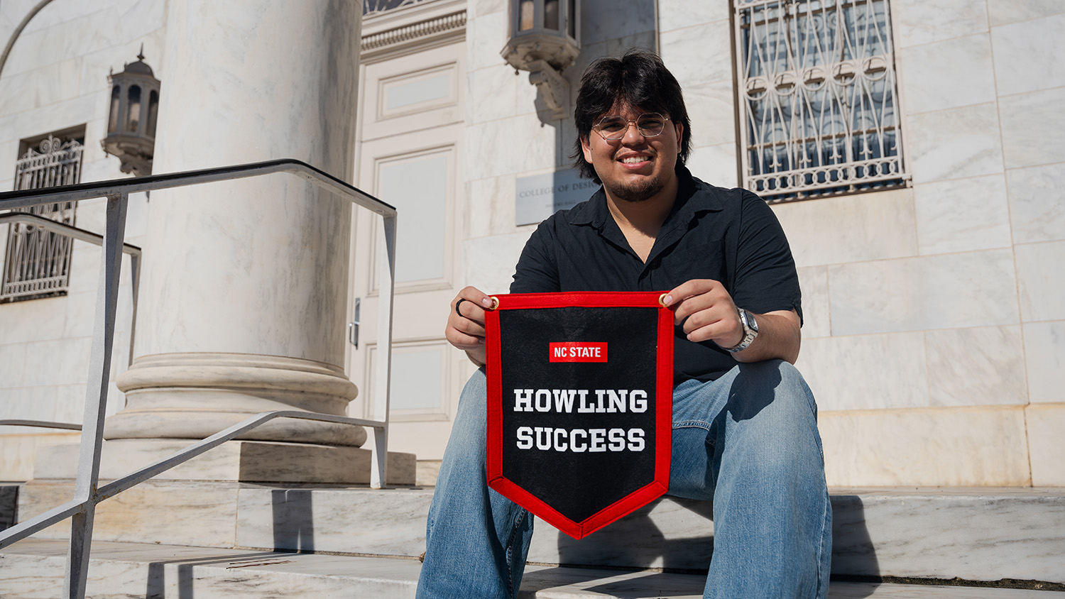 Jimmy Ramirez proudly displays his Howling Success banner outside Brooks Hall.