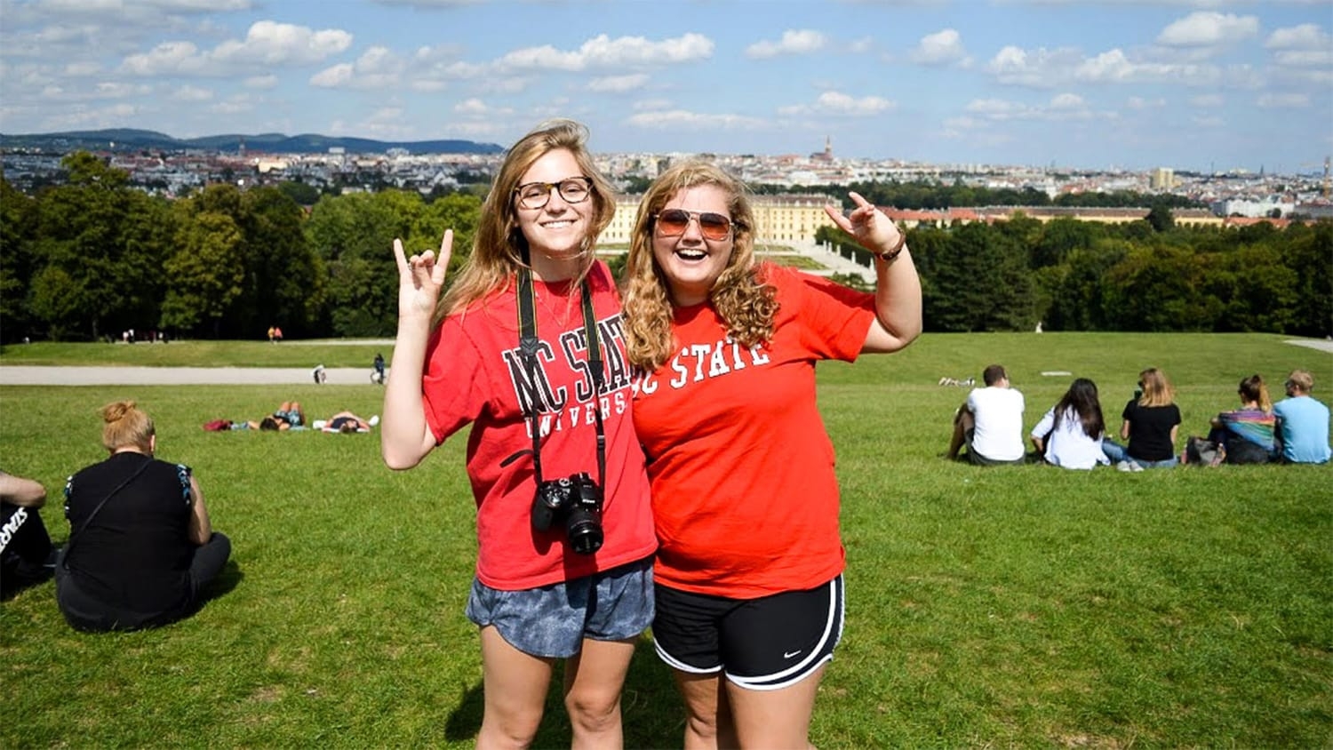 Two students in NC State gear pose for a picture in Prague