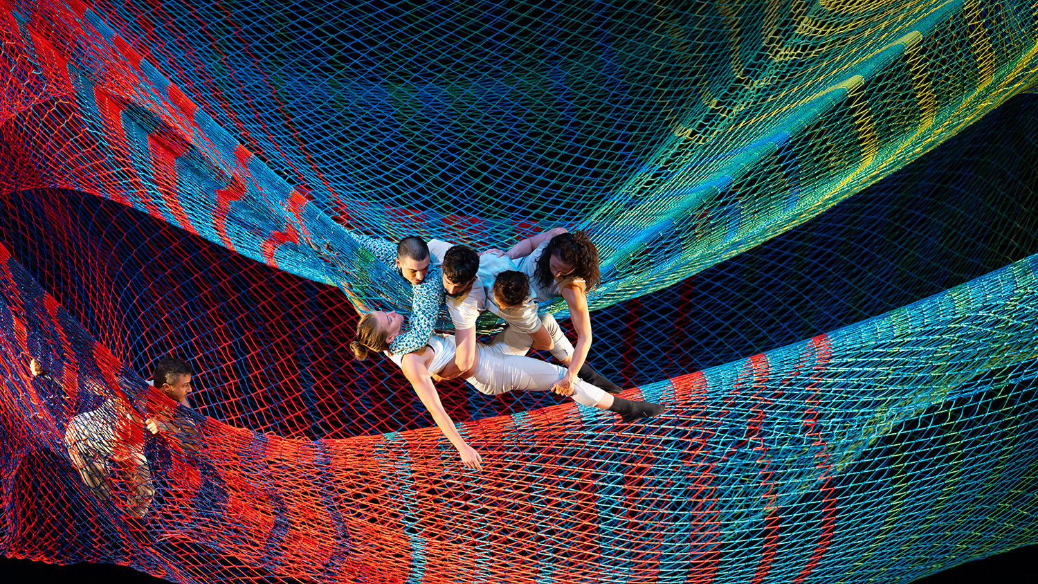Dancers weave through a multi-colored net as part of Rebecca Lazier's NOLI TIMERE, which recently came to campus for a week through NC State LIVE.