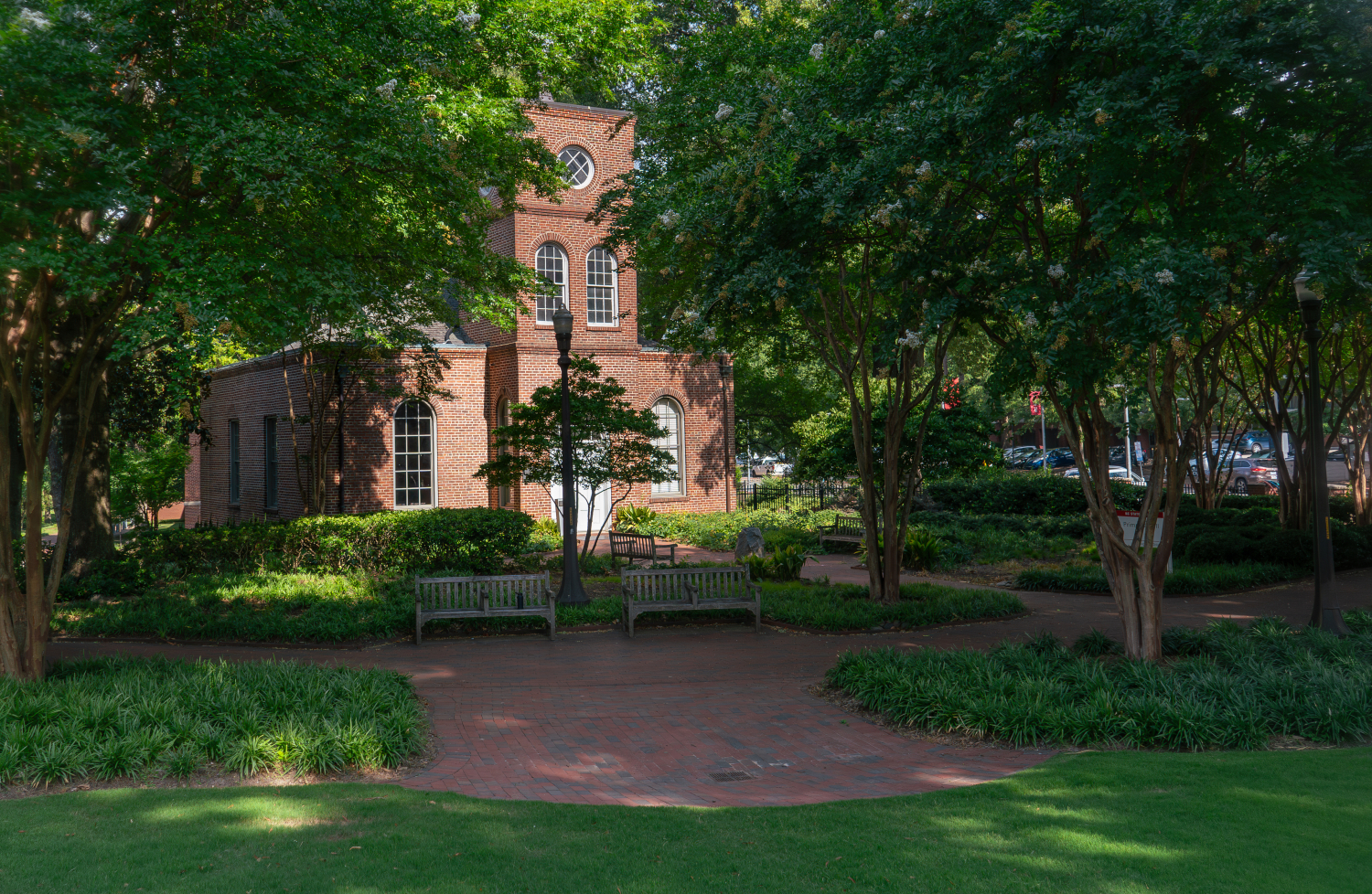 Primrose Hall amidst green trees in the sunlight of summer.