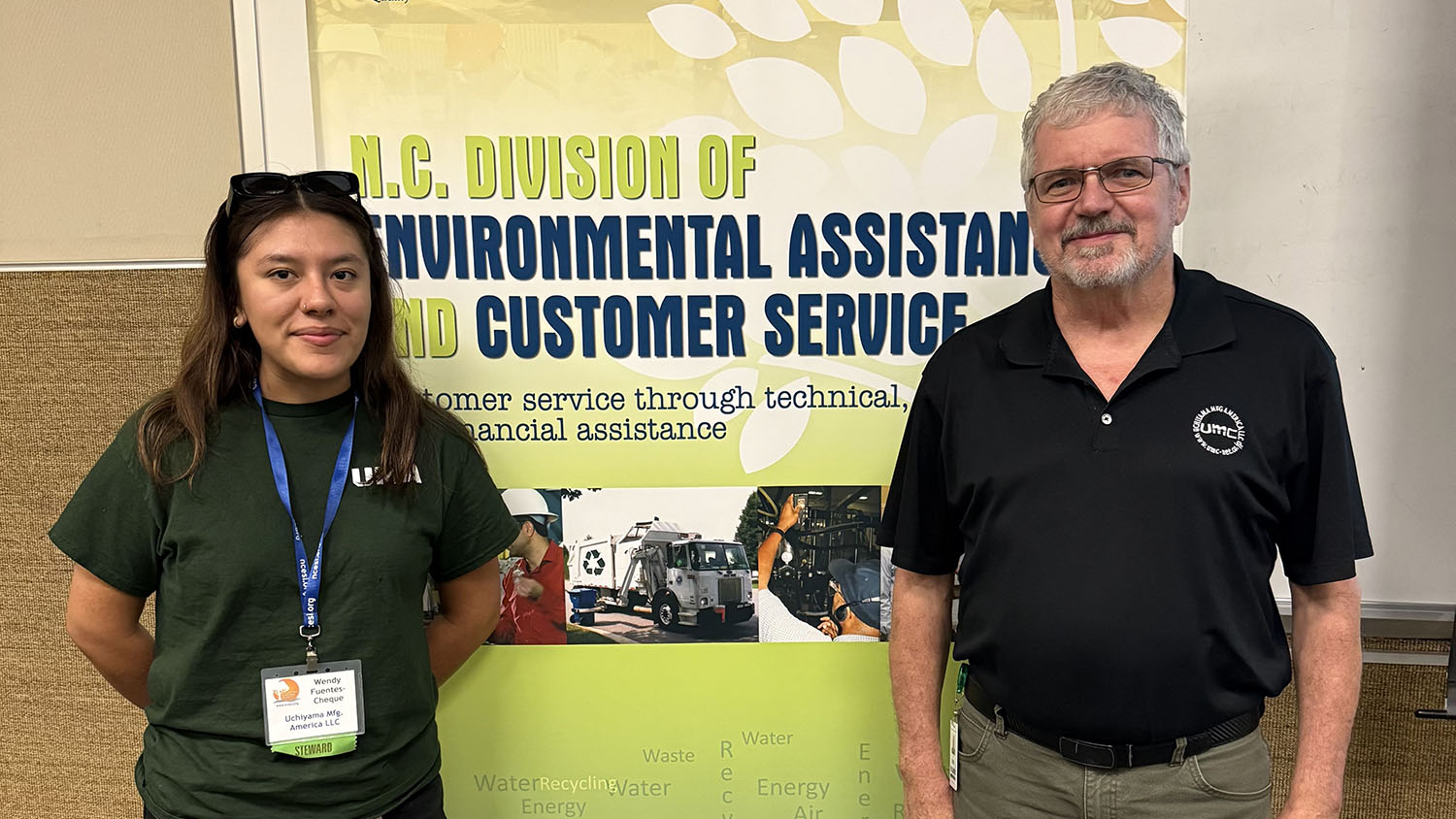a woman and man stand in front of a sign that says nc division of environmental assistance and customer service