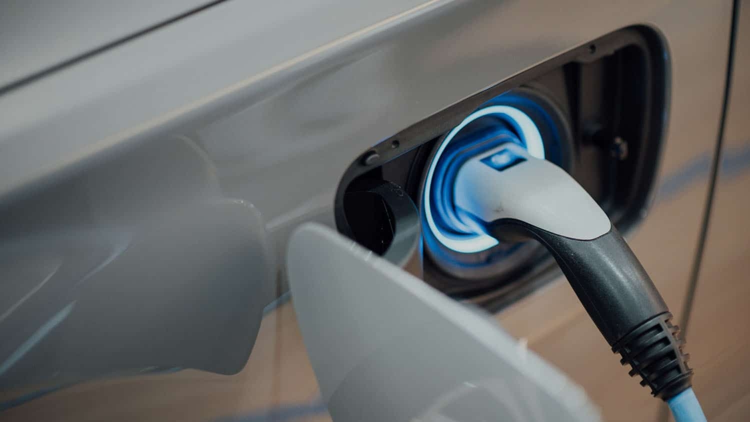 a charging cable is plugged into the port of an electric car