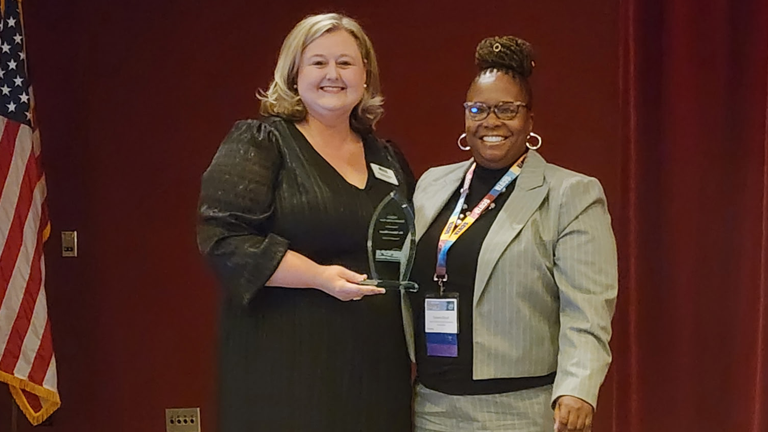 Taheera Blount ’17PHD stands with another woman as she receives the 2025 North Carolina School Counselor Association (NCSCA) Counselor Educator of the Year award.