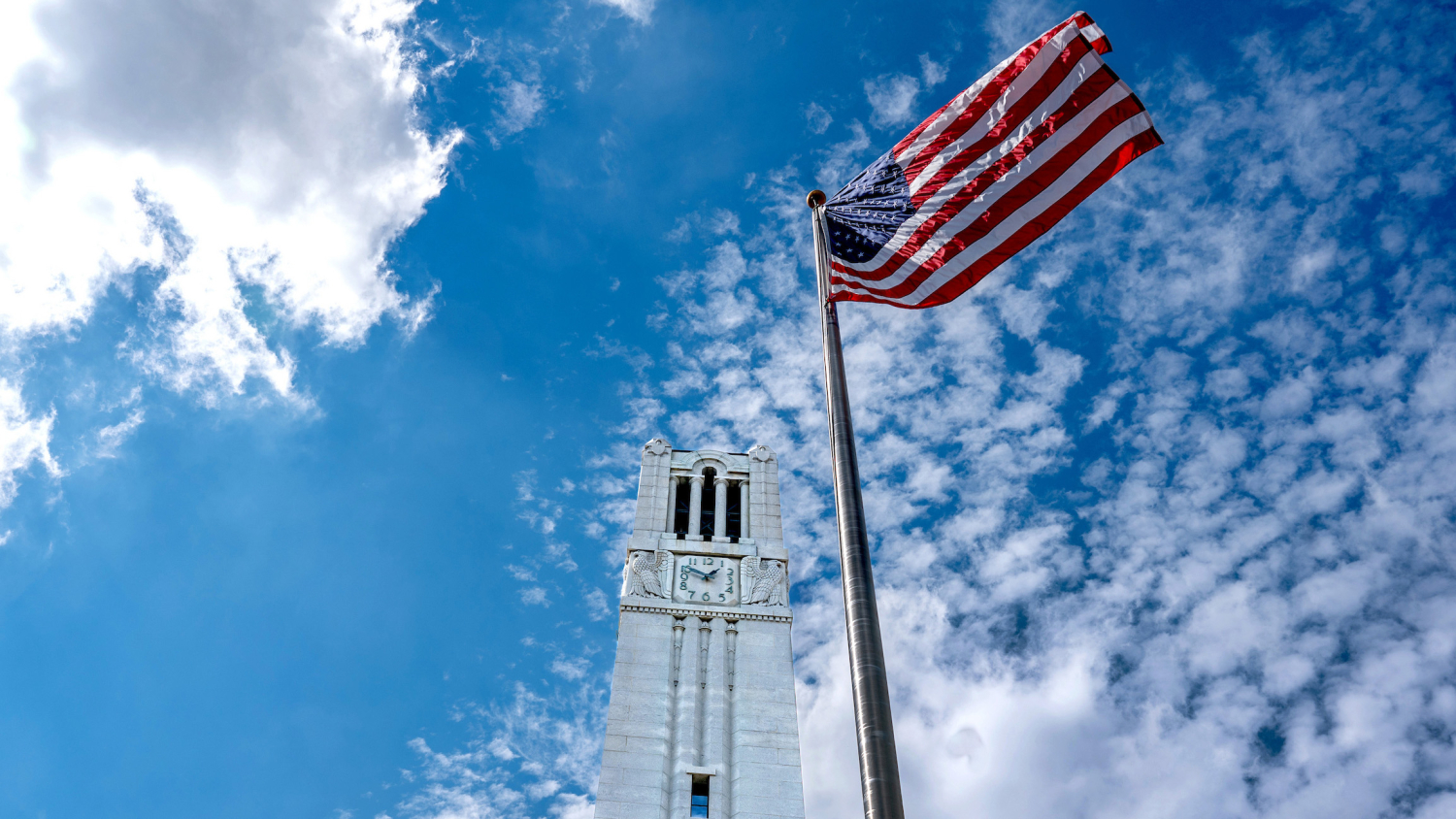 The U.S. flag flies in front of NC State's iconic Memorial Belltower