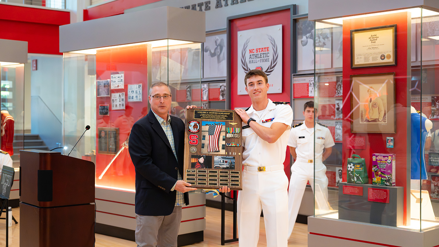 Brad Cranford, Eric Cranford's younger brother, presents the Lieutenant Commander Eric A. Cranford Scholarship to its first recipient: Midshipman Sean O'Connor.