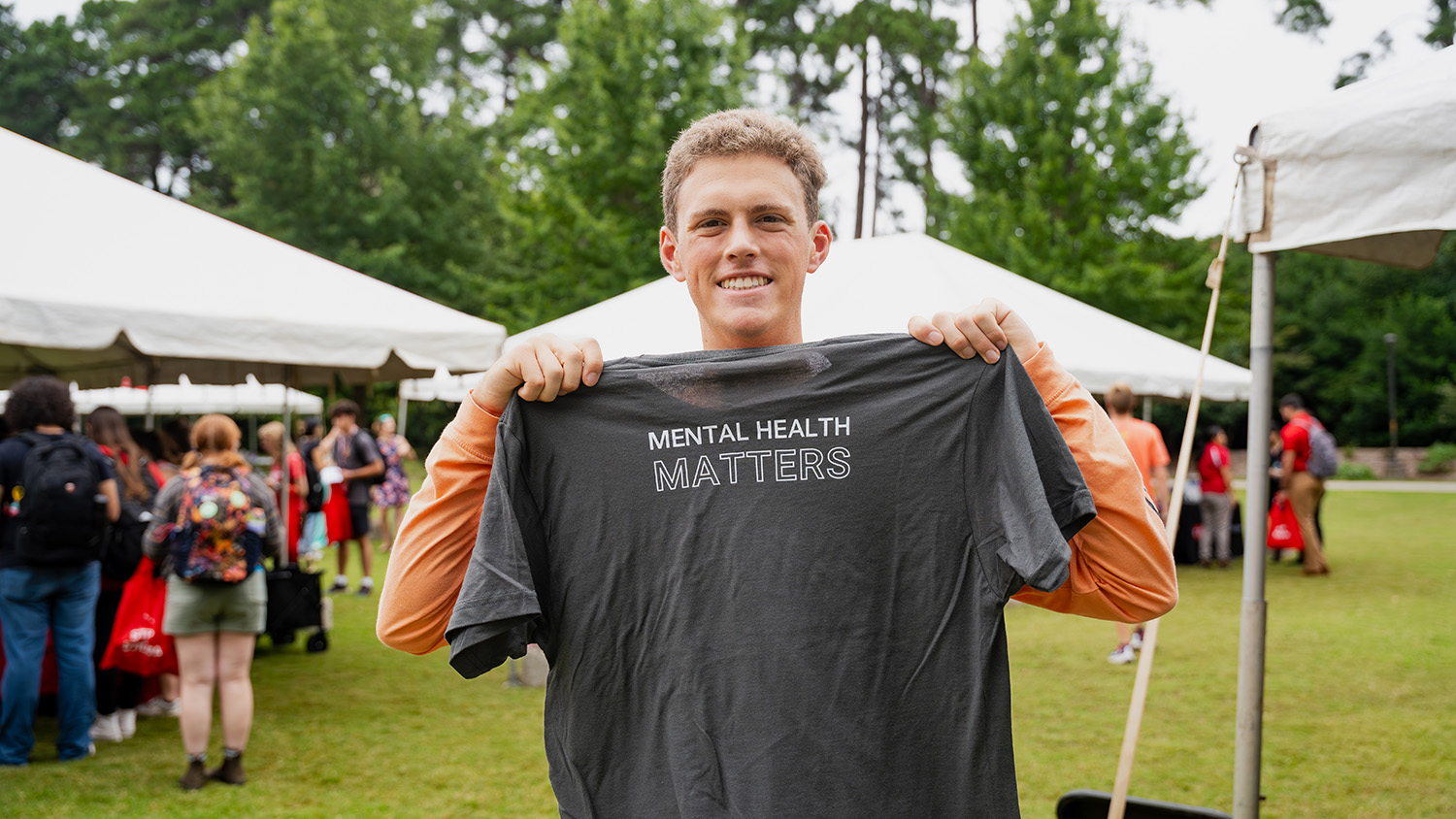A student holds up a "mental health matters" t-shirt.
