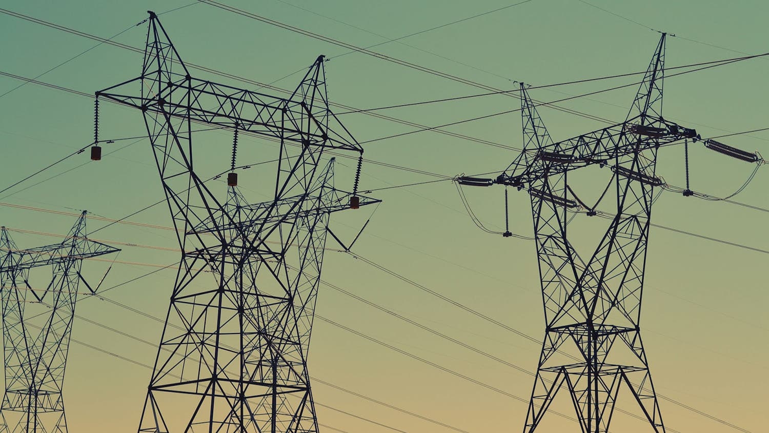 power transmission lines are silhouetted against the skyline