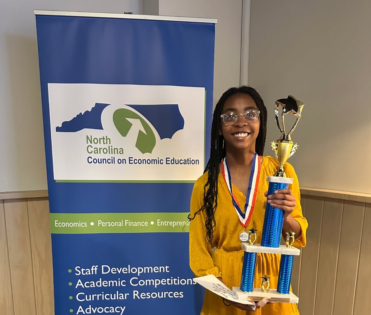 A young teenage girl holds a trophy and wears a medal around her neck