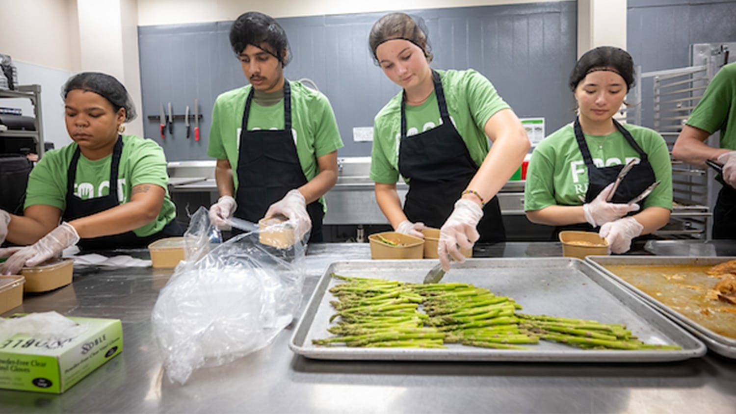 Student volunteers package asparagus from a dining hall as part of the Food Recovery Network Initiative.
