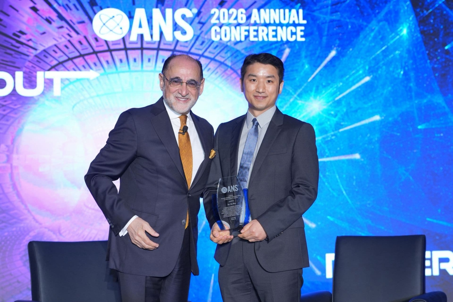 man on left presents award to man on right