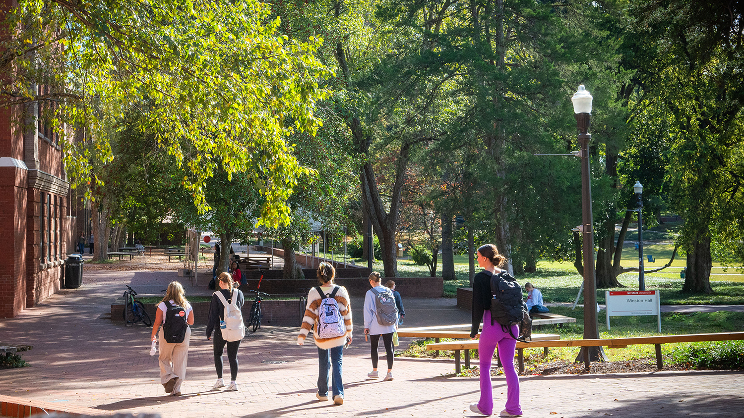 Students walking in front of one of the buildings that make up the College of Humanities and Social Sciences.