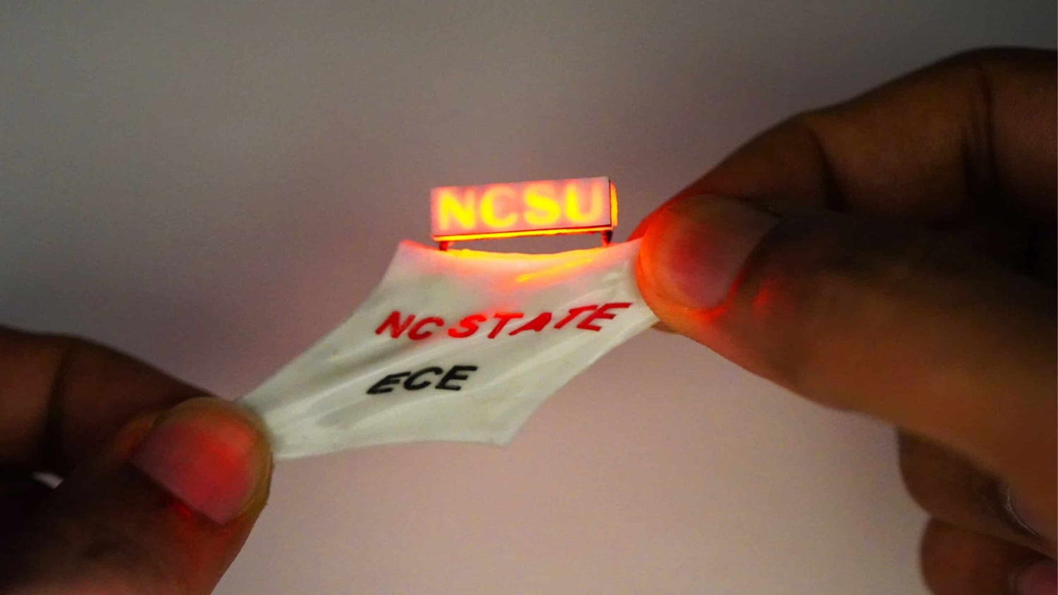 Battery being stretched while lighting up a tiny NCSU sign