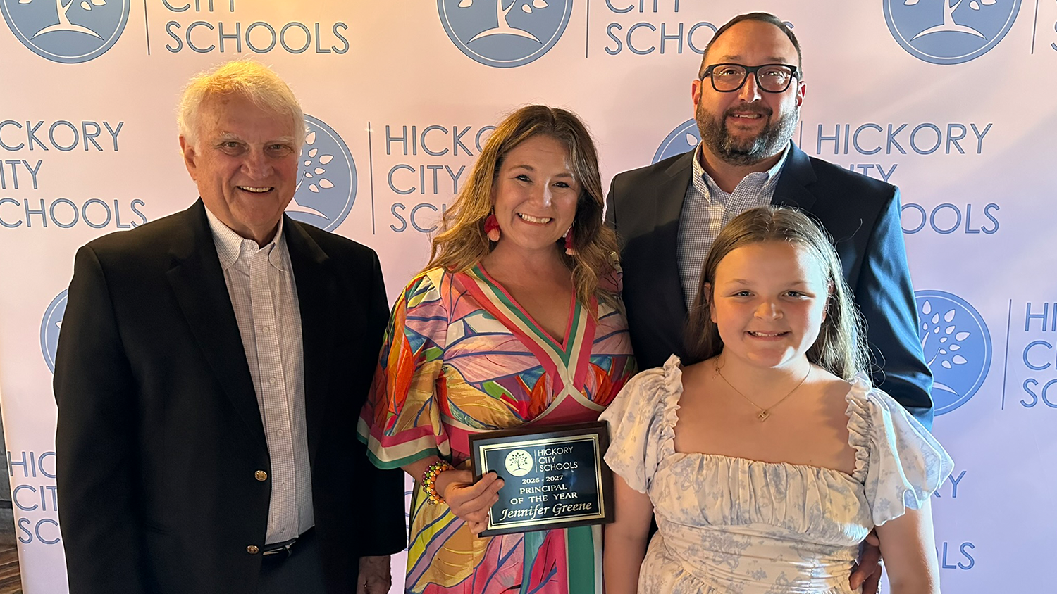 Jennifer Greene poses with her family and holds her Principal of the Year award.