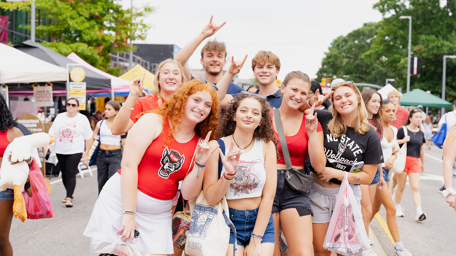 Students throw up their Wolfies for a group photo on Hillsborough Street.