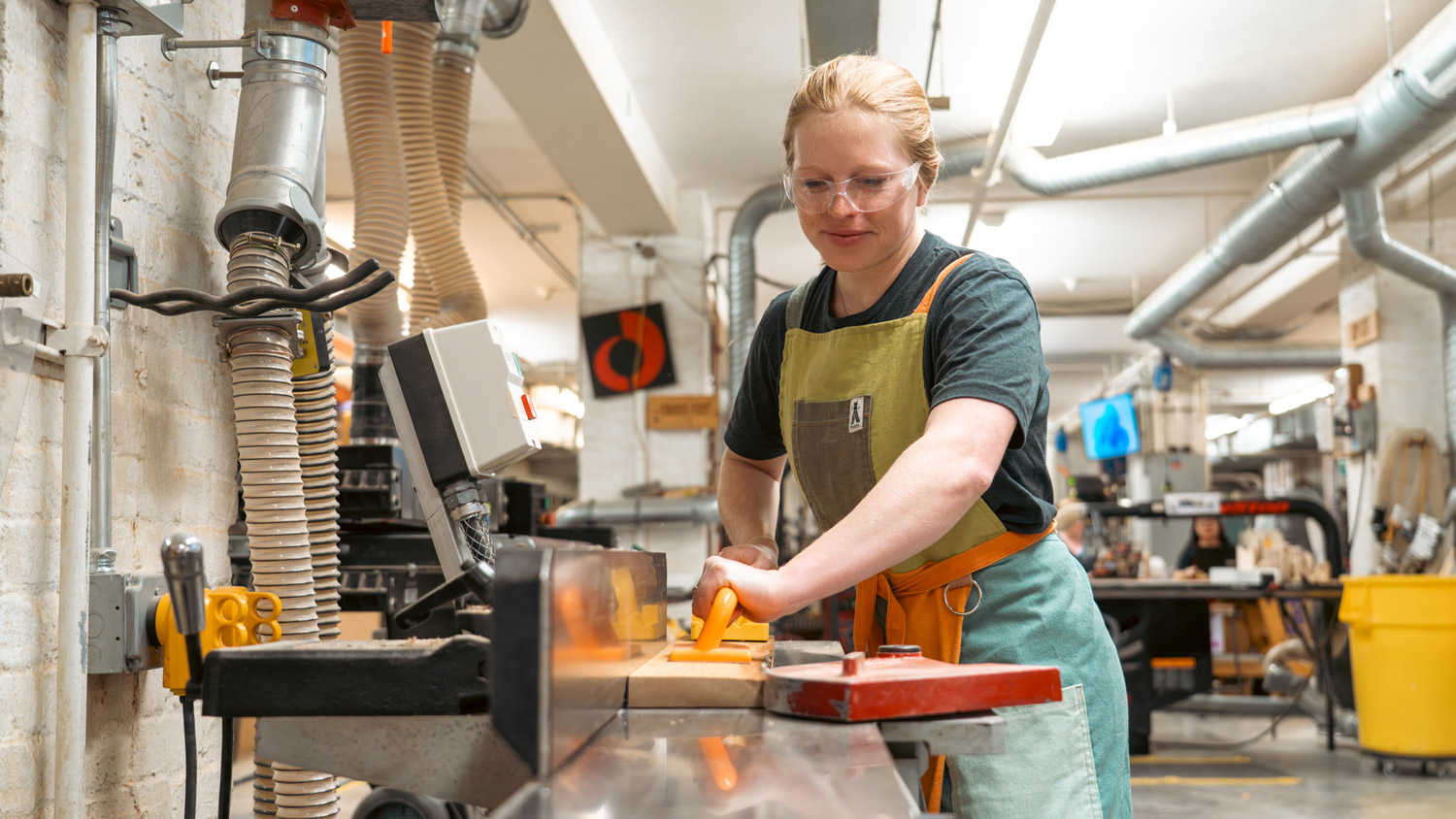 Lindsay Dotson cuts wood from a felled tree at the College of Design for her studio project.