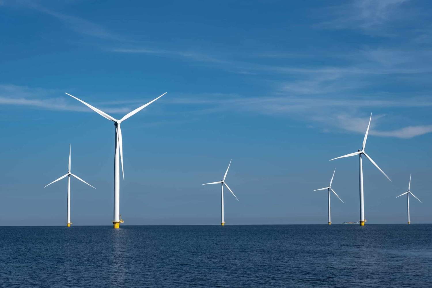 An aerial view off offshore wind turbines in the ocean.