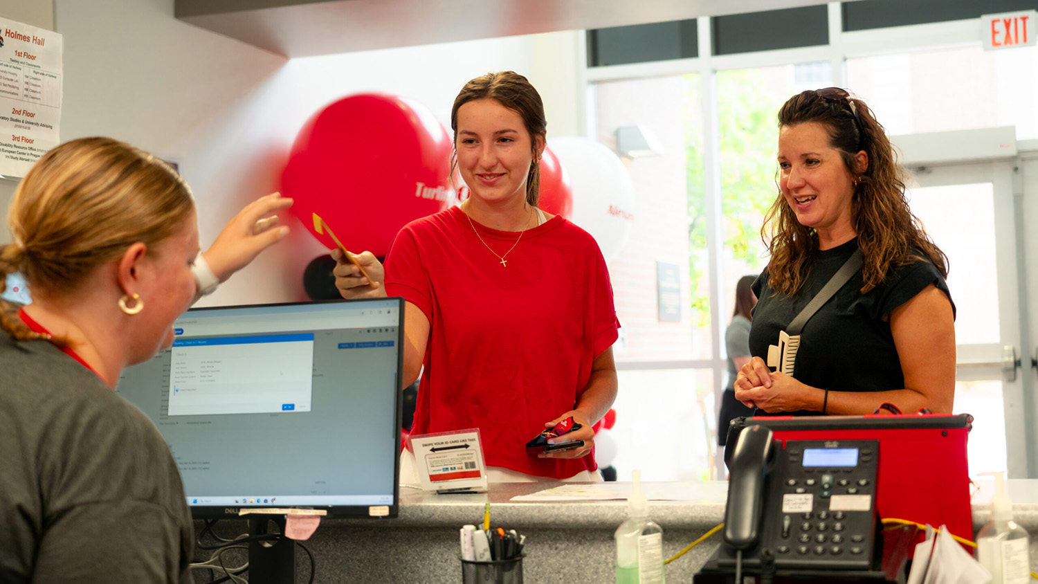 Parent and student arriving at the check-in desk to receive their key.