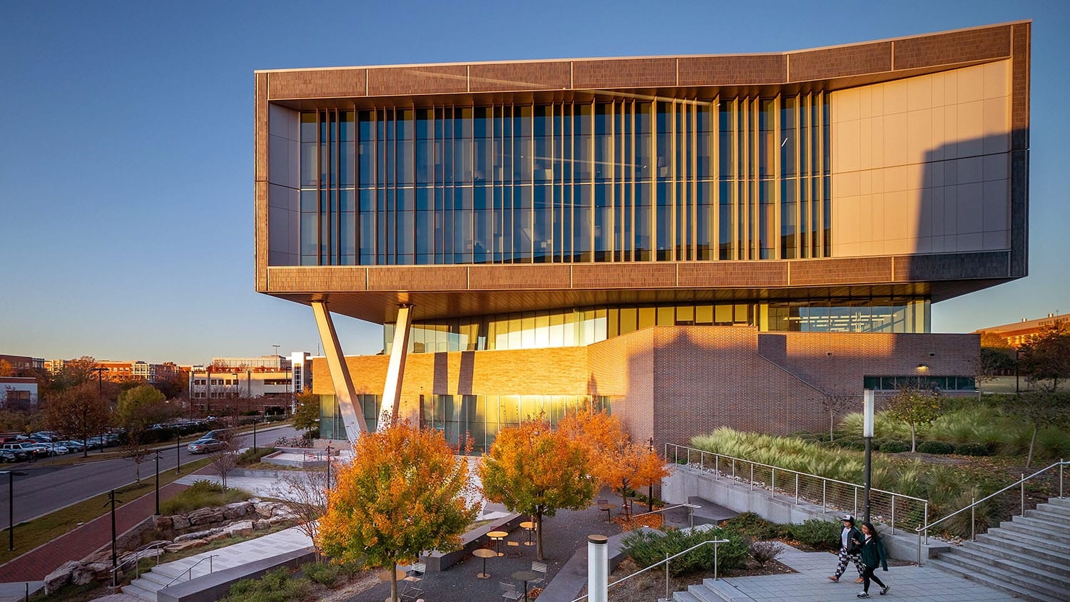 the setting sun casts warm light on a futuristic looking building