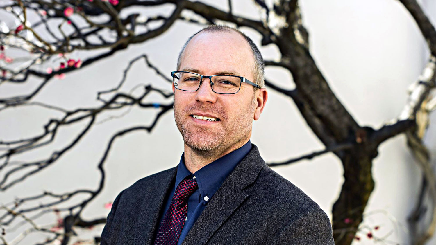Richard T. Olsen standing in front of a tree