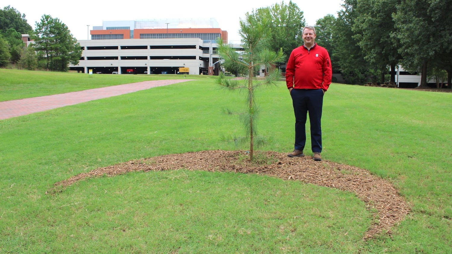 Plant Sciences Building operations manager Geoff Bock next to the "Moon Tree."