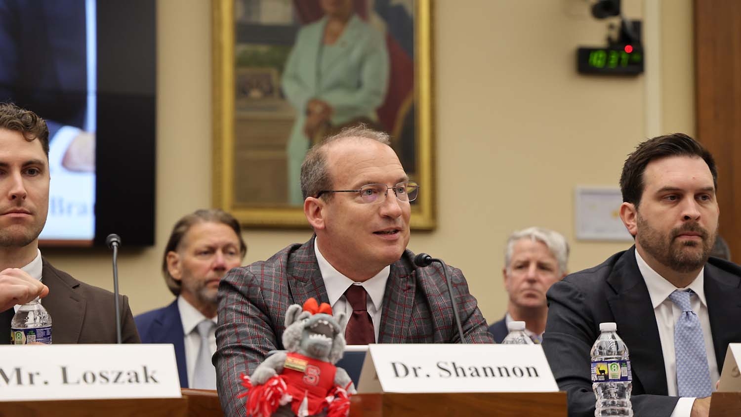 A man sitting at a Congressional hearing with a name tag reading "Steve Shannon".