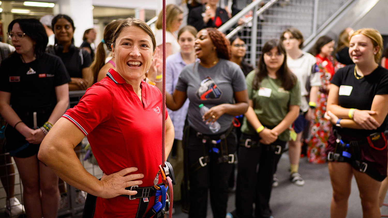 Christina Koch smiles in front of a group of students.
