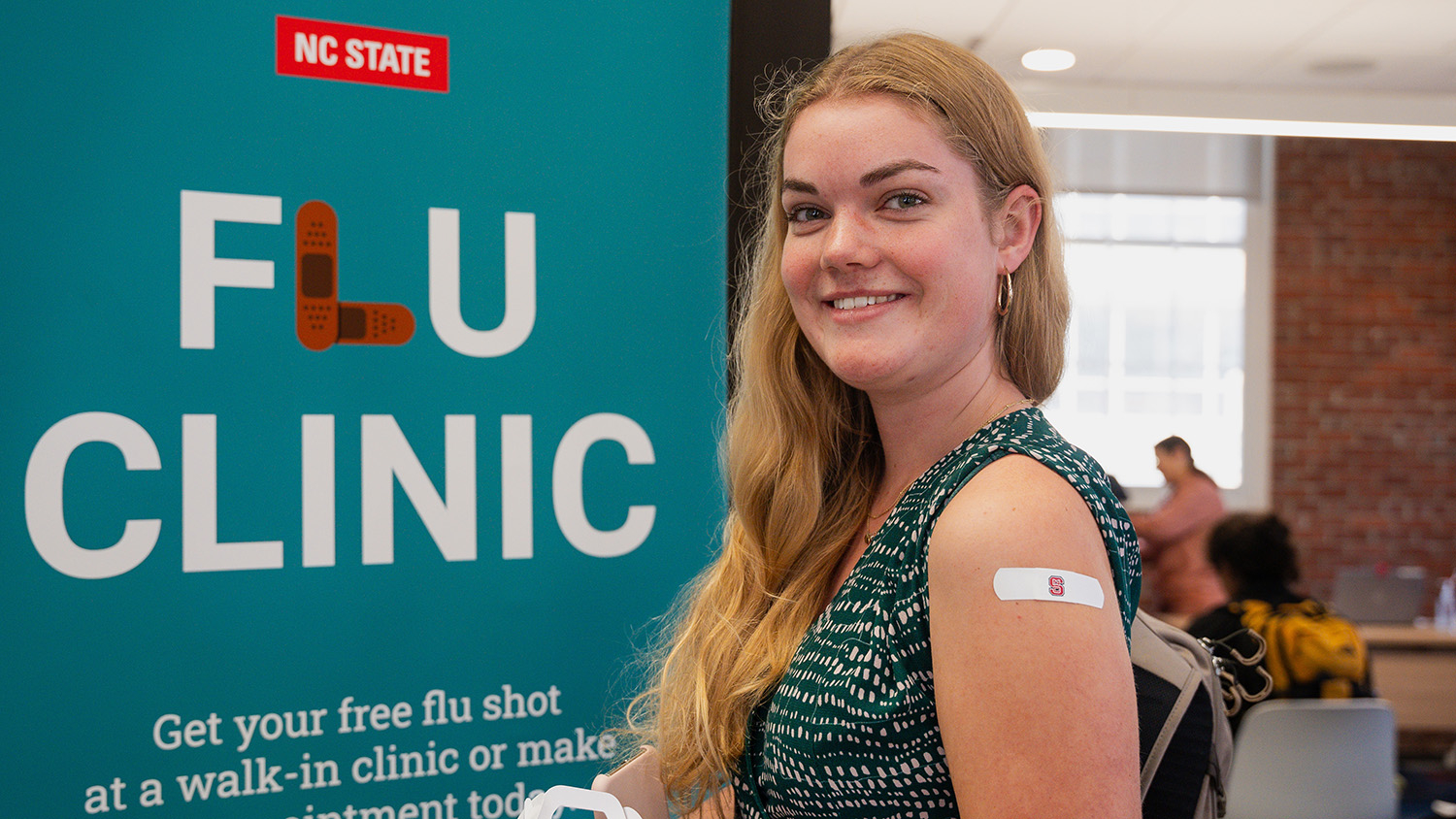 A student sports a red and white NC State band-aid after receiving a flu shot.