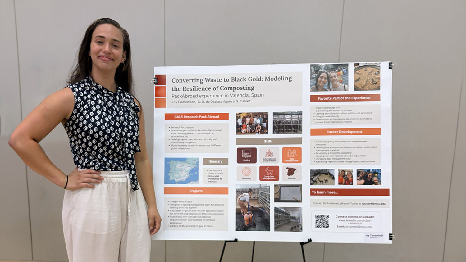 a woman stands next to a research poster that cays converting waste to black gold modeling the resilience of composting